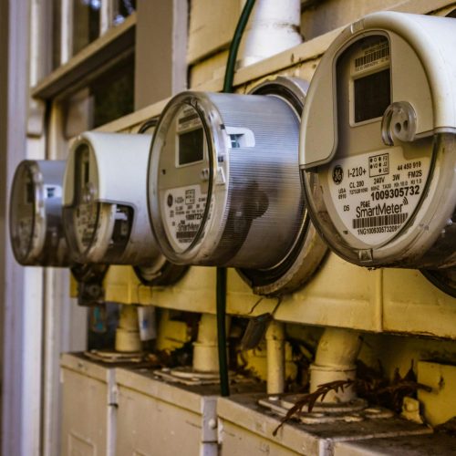 Image of multiple smart electricity meters installed on a residential exterior wall, showing environmental adaptation.